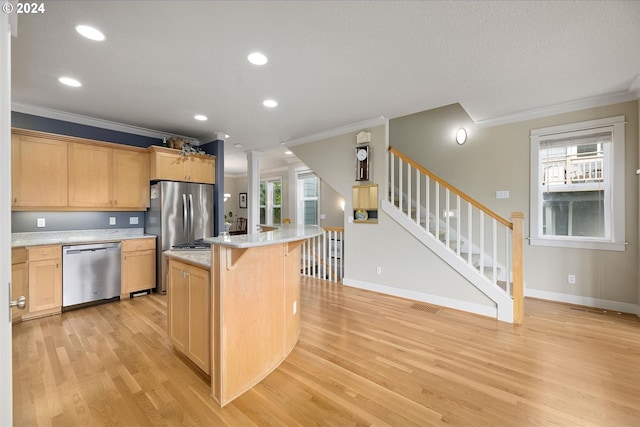 kitchen featuring ornamental molding, light hardwood / wood-style flooring, a center island, light stone countertops, and appliances with stainless steel finishes