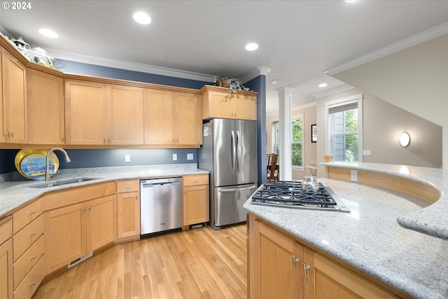 kitchen featuring ornamental molding, stainless steel appliances, light stone counters, and a sink