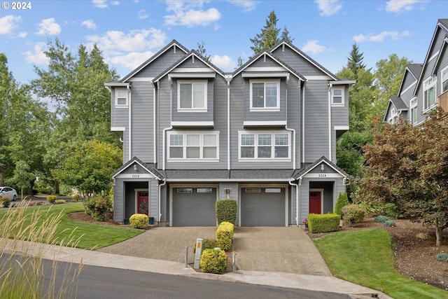 view of front of home with driveway, an attached garage, and a front yard