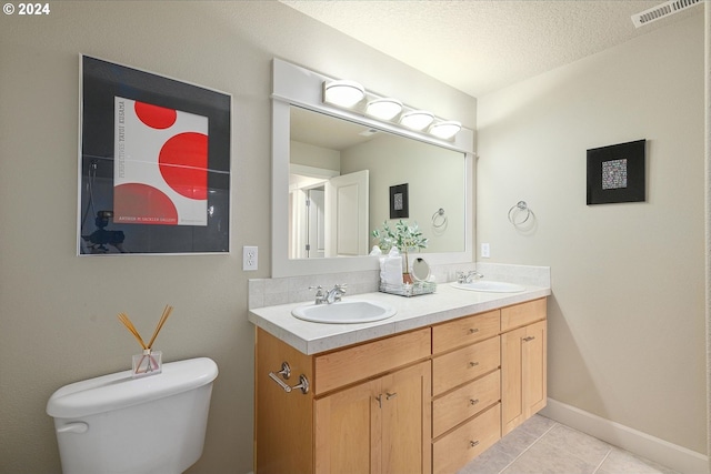 bathroom featuring tile patterned flooring, vanity, toilet, and a textured ceiling