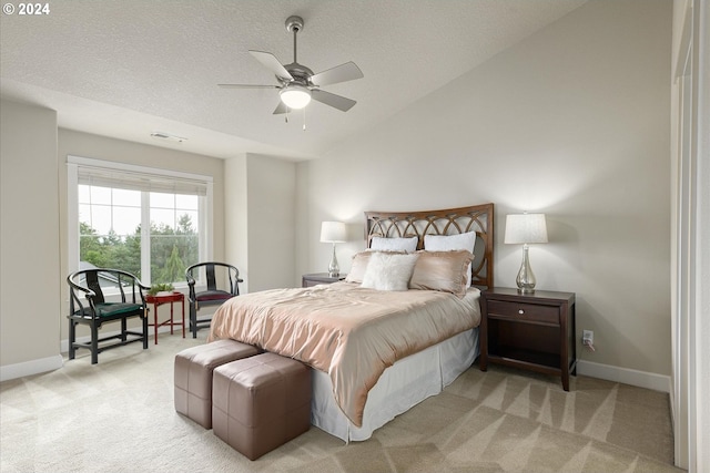 bedroom with light colored carpet, vaulted ceiling, and ceiling fan