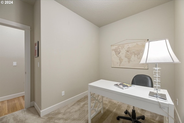 home office with a textured ceiling and light colored carpet