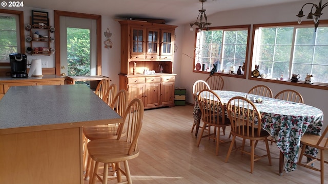 dining space with light hardwood / wood-style flooring and an inviting chandelier