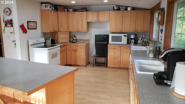 kitchen with light brown cabinets, white appliances, sink, and light hardwood / wood-style flooring