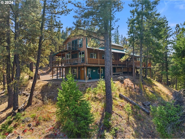 back of property featuring a deck and a patio