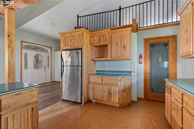 kitchen with light brown cabinets and stainless steel refrigerator