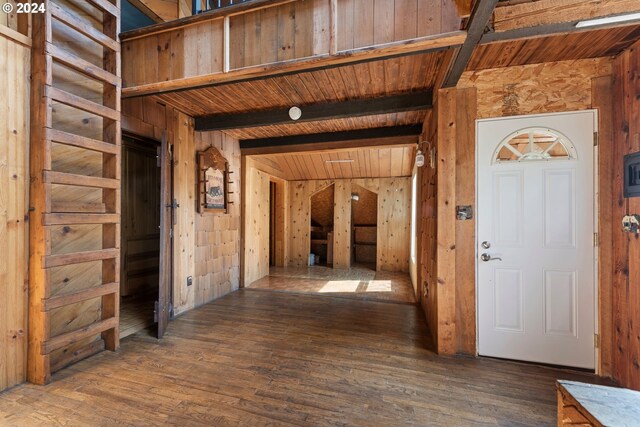 foyer entrance featuring wood ceiling, dark hardwood / wood-style floors, and wooden walls