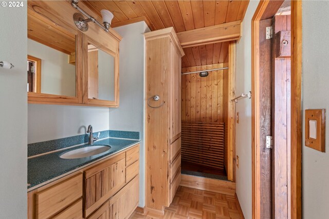 bathroom with wood ceiling, walk in shower, parquet flooring, and vanity