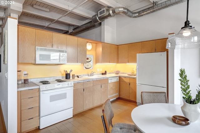 kitchen featuring decorative light fixtures, white appliances, light hardwood / wood-style flooring, light brown cabinets, and a high ceiling