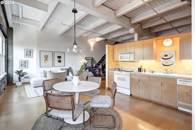 dining area featuring wood ceiling, light hardwood / wood-style floors, beamed ceiling, and sink