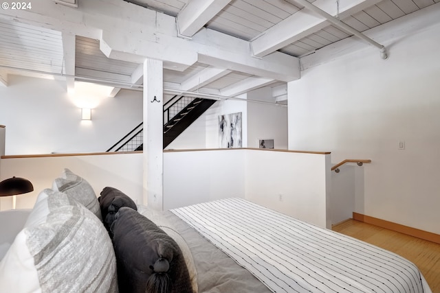 bedroom featuring light wood-type flooring, beam ceiling, and wooden ceiling