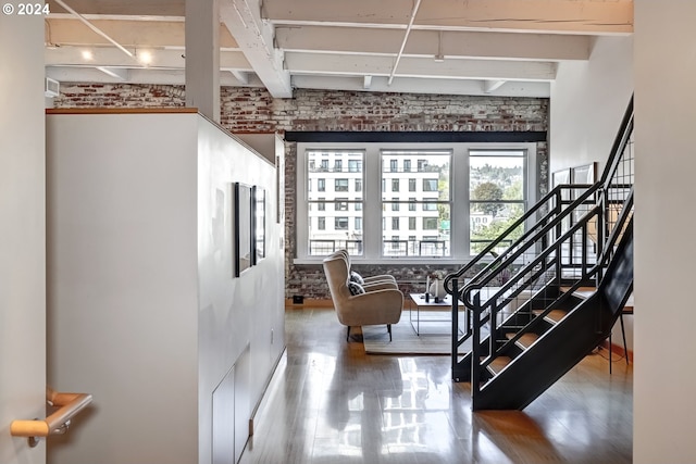 entrance foyer featuring hardwood / wood-style flooring and brick wall