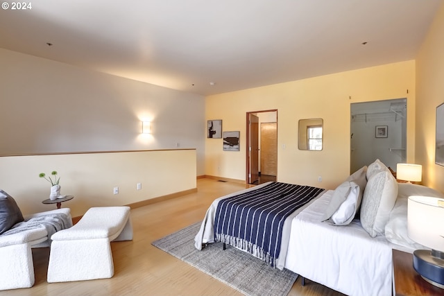 bedroom featuring a closet, a spacious closet, and light hardwood / wood-style flooring