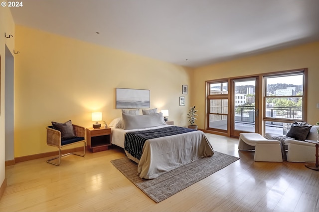 bedroom with access to outside and light hardwood / wood-style flooring