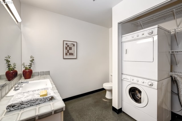 washroom with sink and stacked washer / dryer