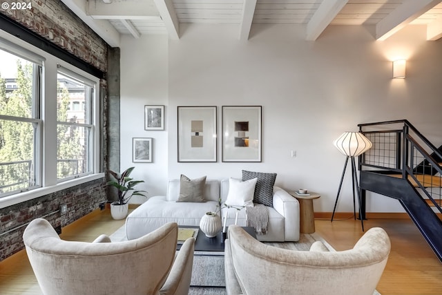 interior space featuring wood ceiling, beamed ceiling, light hardwood / wood-style flooring, and brick wall