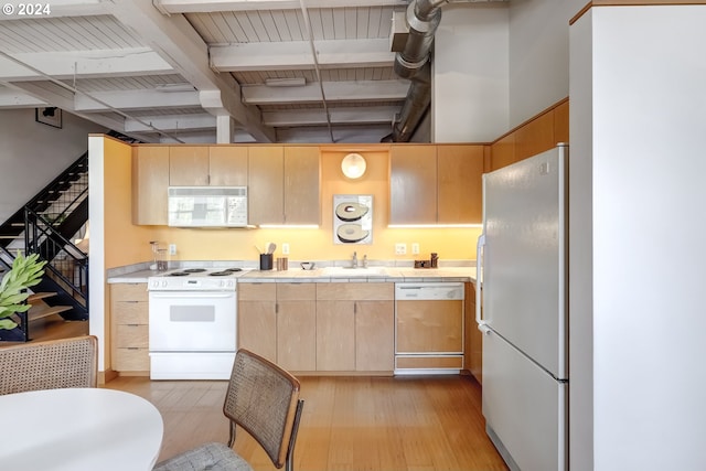 kitchen featuring white appliances, light hardwood / wood-style flooring, light brown cabinetry, beam ceiling, and sink