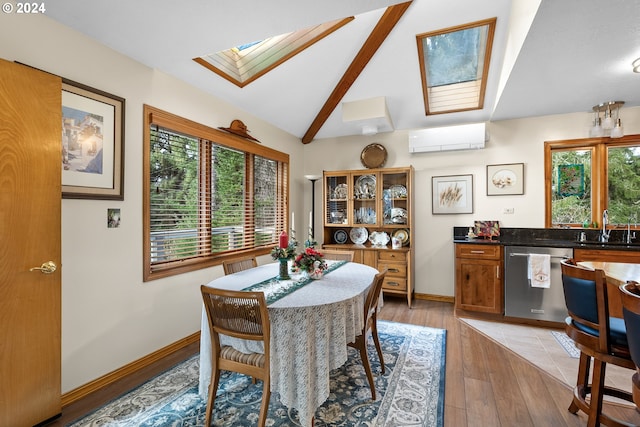 dining area featuring lofted ceiling with skylight, sink, a wall mounted AC, and light wood-type flooring