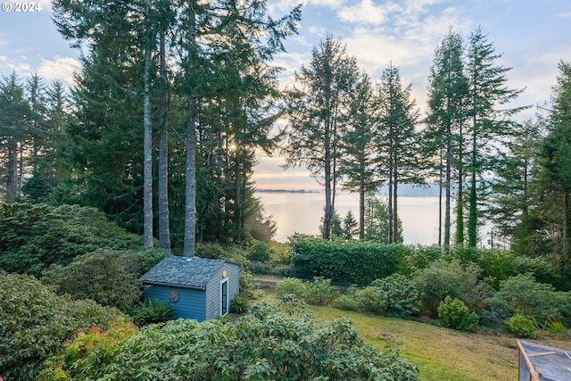 yard at dusk featuring a water view