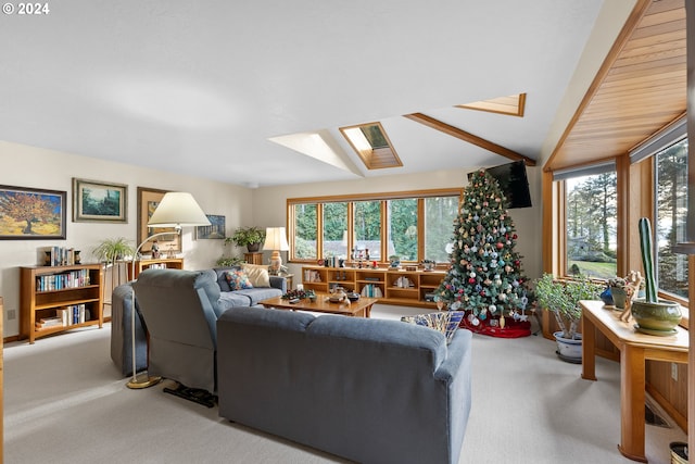 living room featuring a healthy amount of sunlight, lofted ceiling with skylight, and carpet