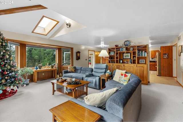 living room featuring vaulted ceiling with skylight and light carpet