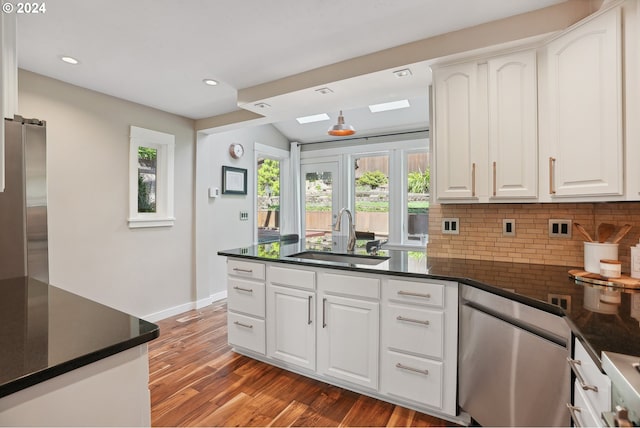 kitchen featuring dark wood-type flooring, sink, decorative backsplash, appliances with stainless steel finishes, and white cabinetry