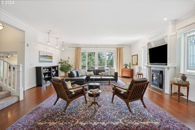 living room featuring ornamental molding, a wealth of natural light, and dark wood-type flooring