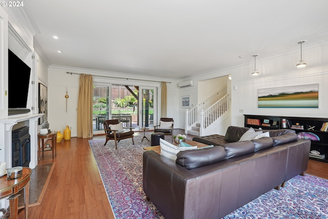 living room featuring ornamental molding, a wall mounted air conditioner, and hardwood / wood-style flooring