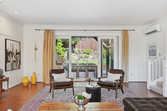 living room with a wall mounted air conditioner, ornamental molding, and hardwood / wood-style floors