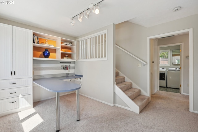 carpeted office with washing machine and dryer and track lighting