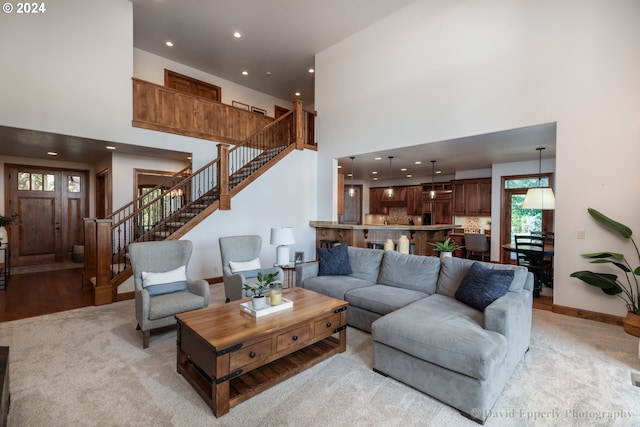 living room with a high ceiling and light carpet