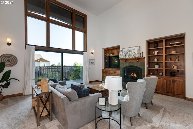 living room featuring light colored carpet, plenty of natural light, a high ceiling, and a tile fireplace