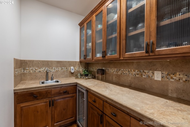 bar featuring wine cooler, sink, and backsplash