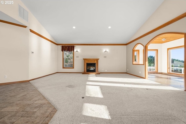 unfurnished living room with light carpet, plenty of natural light, and vaulted ceiling