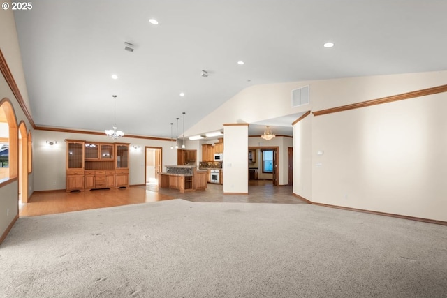 unfurnished living room with light colored carpet, vaulted ceiling, and a notable chandelier