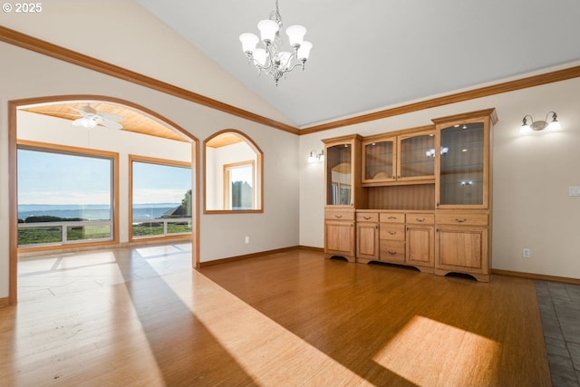 interior space with ornamental molding, ceiling fan with notable chandelier, hardwood / wood-style flooring, a mountain view, and lofted ceiling