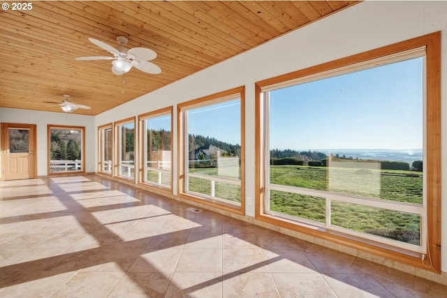 unfurnished sunroom featuring a rural view, ceiling fan, and wood ceiling