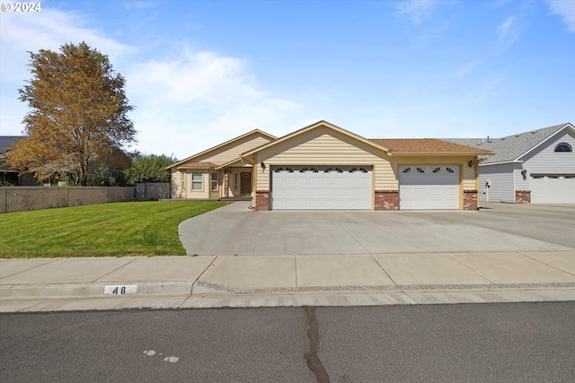 ranch-style house featuring a garage and a front lawn