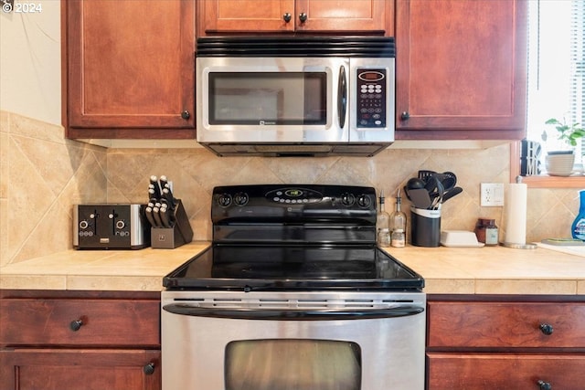 kitchen featuring appliances with stainless steel finishes and tasteful backsplash