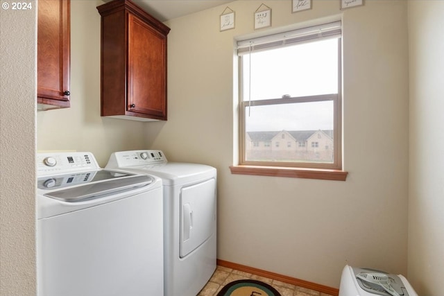 laundry room featuring washer and dryer, cabinets, and light tile patterned floors