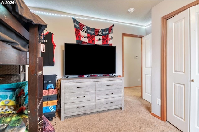 bedroom with a textured ceiling and light carpet