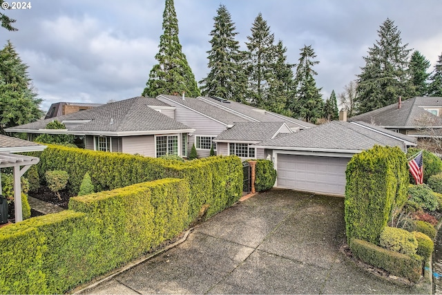 single story home featuring a garage, driveway, and a shingled roof