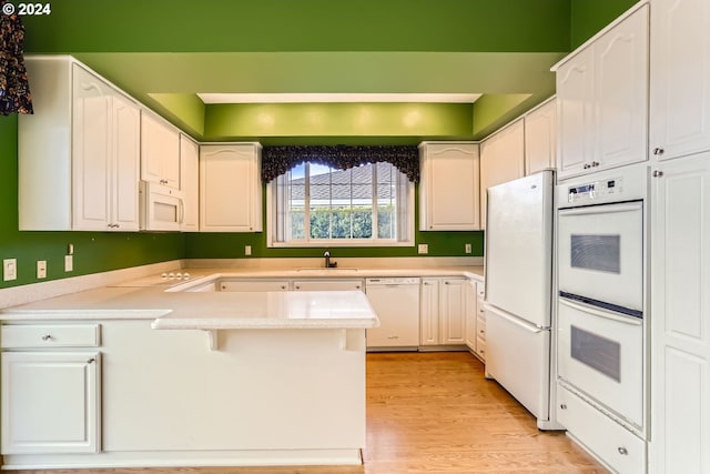 kitchen featuring sink, white cabinets, white appliances, and light wood-type flooring