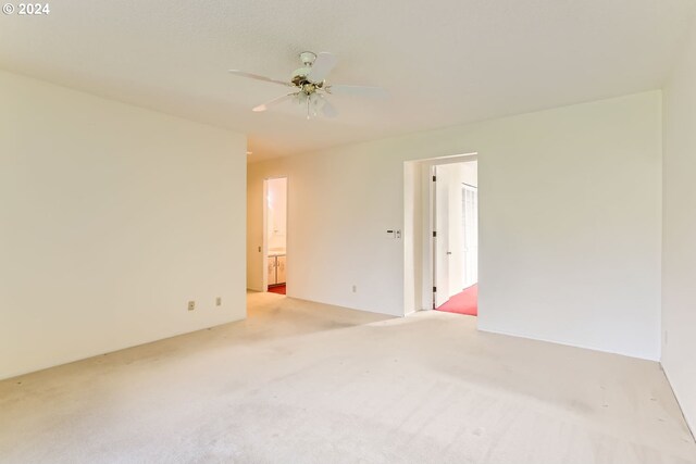 carpeted spare room featuring ceiling fan