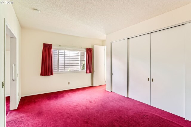 unfurnished bedroom with a closet, carpet, and a textured ceiling