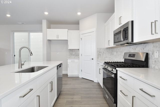 kitchen featuring appliances with stainless steel finishes, white cabinetry, and sink