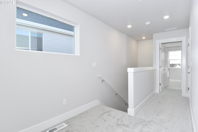 hall with light colored carpet