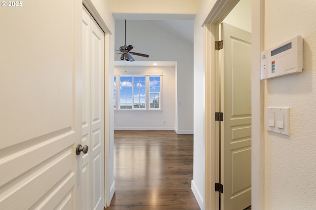 hallway featuring vaulted ceiling and dark wood-type flooring