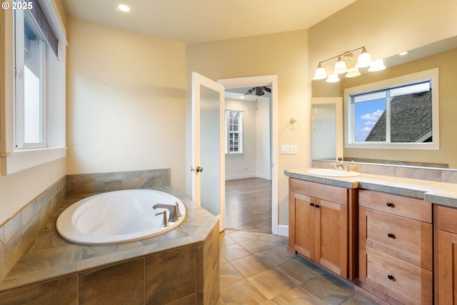 bathroom featuring vanity, tile patterned flooring, and tiled tub