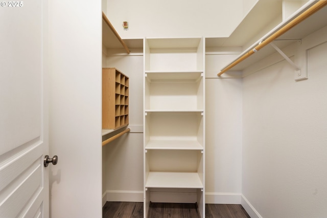 walk in closet with dark wood-type flooring